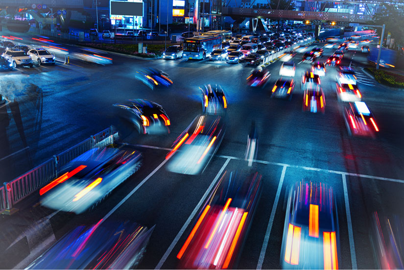 Blurred images of cars at night driving through a traffic light - depicting attracting traffic to your site