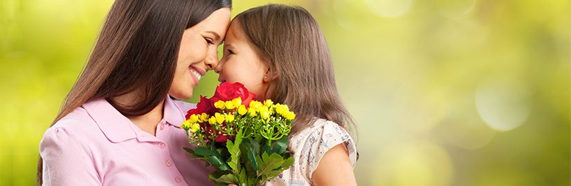 Image of a daughter and mother holding flowers and looking into each others eyes
